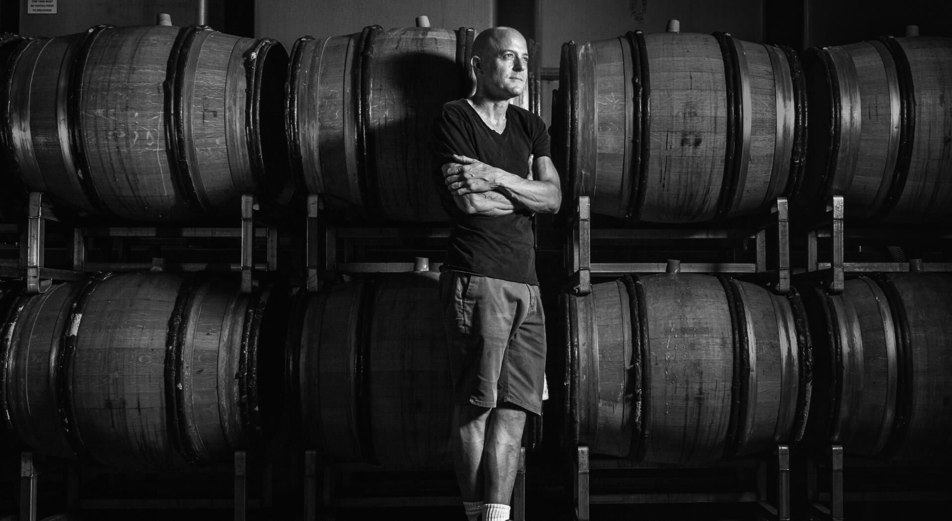 Greg Brewer by some wine barrels